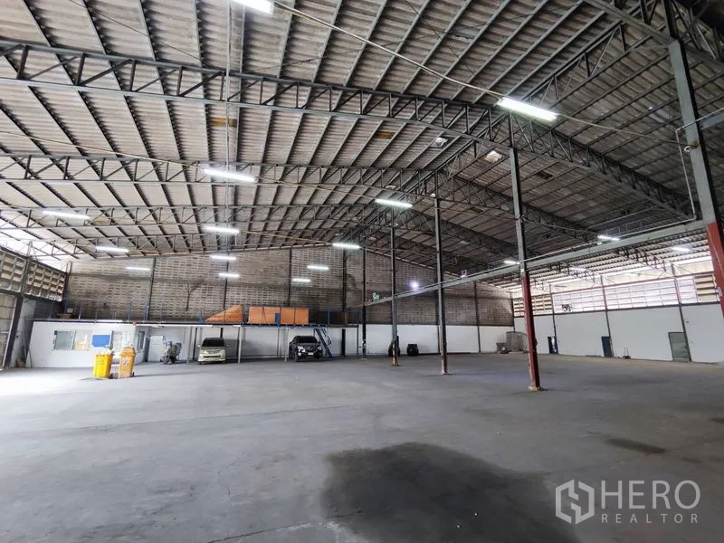 Warehouse for rent in Bang Phli, Samut Prakan - Open-plan warehouse floor with steel columns, concrete slab and mezzanine platforms along the walls.