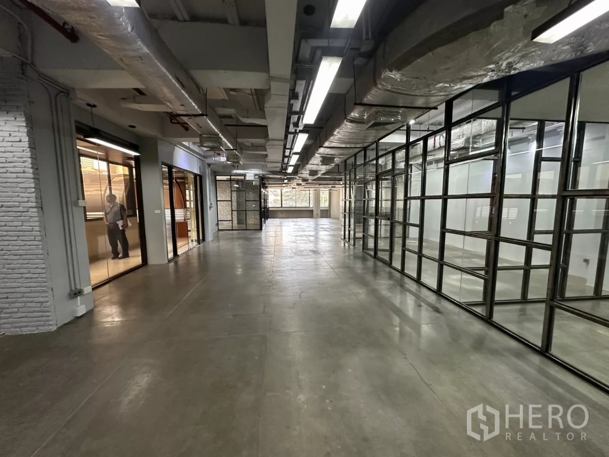Office Space for rent - Entrance corridor with glass partitions and exposed ductwork throughout.