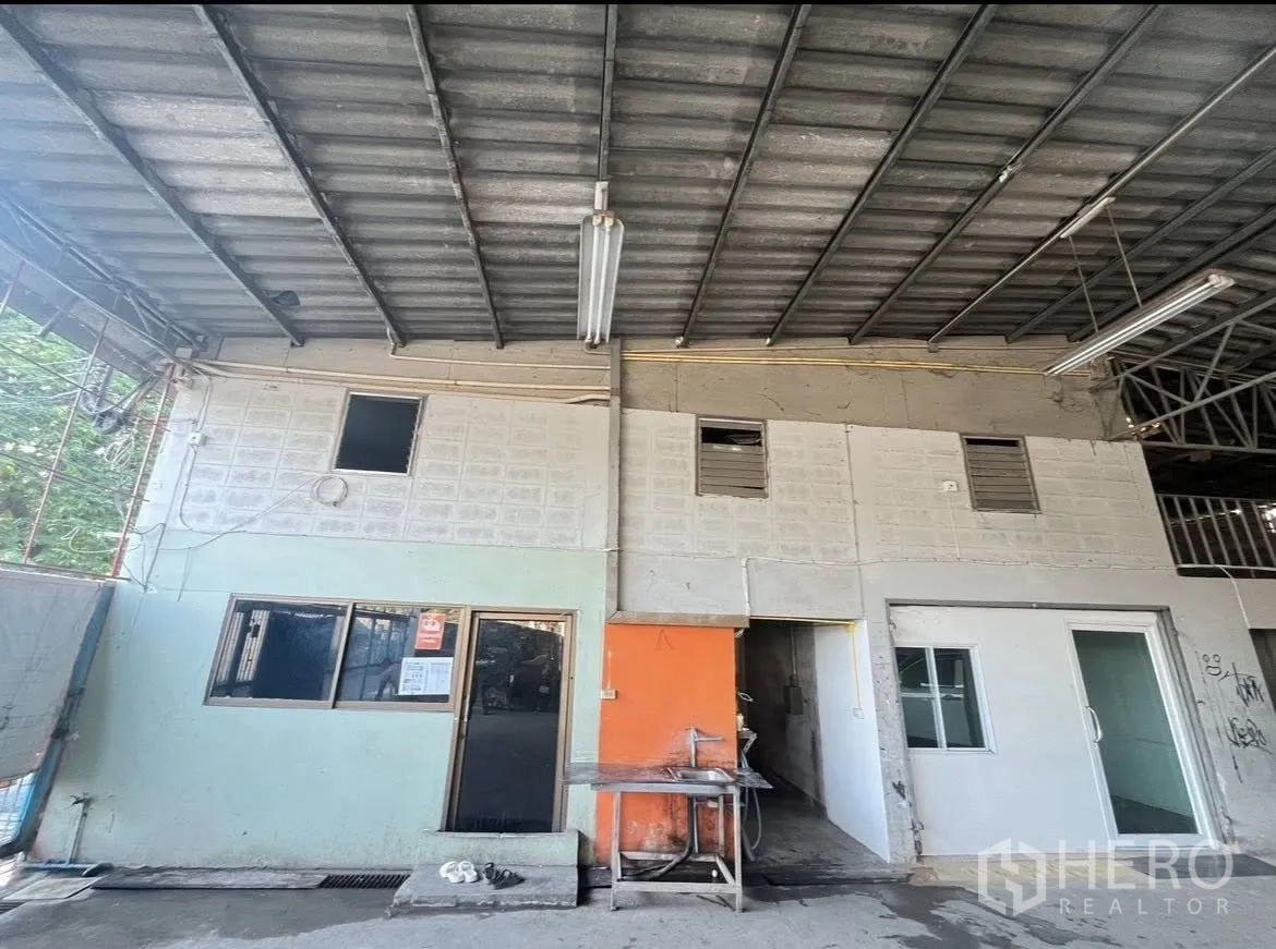 Warehouse for rent in Chatuchak, Bangkok - Front of internal office structures under the warehouse roof with windows and doors.