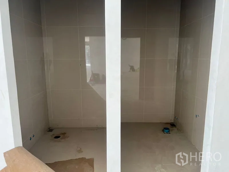Retail Space for rent in Khlong Toei, Bangkok - Two tiled restroom cubicles under construction with plumbing points installed.