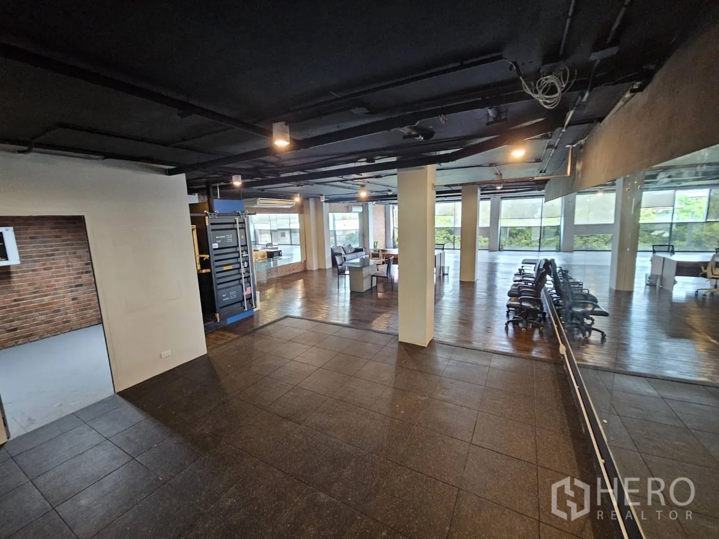 Office Space for rent in Watthana, Bangkok - Entrance zone with dark tiles, mirrored wall, rows of office chairs and open-plan area beyond.