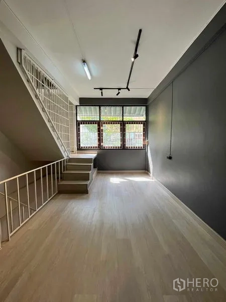 Home Office for rent in Khlong Toei, Bangkok - Bright room with light wood floors, stairway and windows with metal grilles.