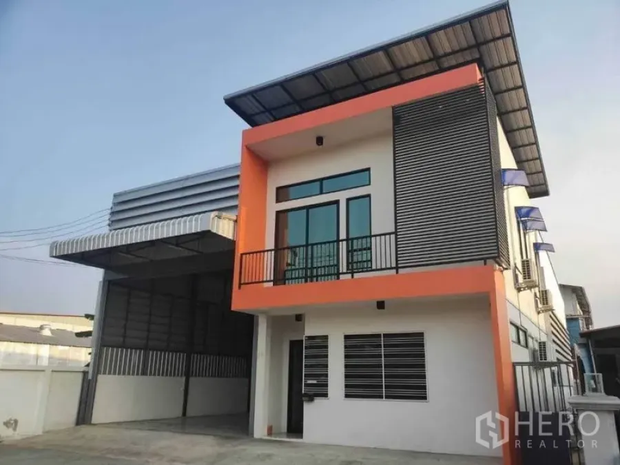 货栈 出租在Lam Luk Ka, Pathum Thani - 当天外观，橙色立面与金属雨棚的现代仓库。