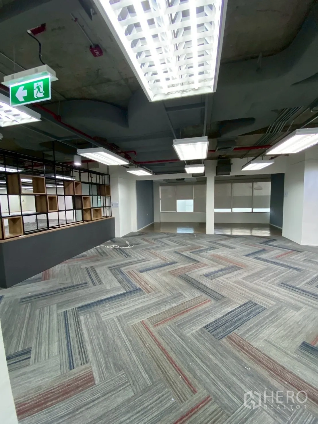 Office Space for rent in Watthana, Bangkok - Spacious workspace with shelving partition, large windows, and bright panel lights.