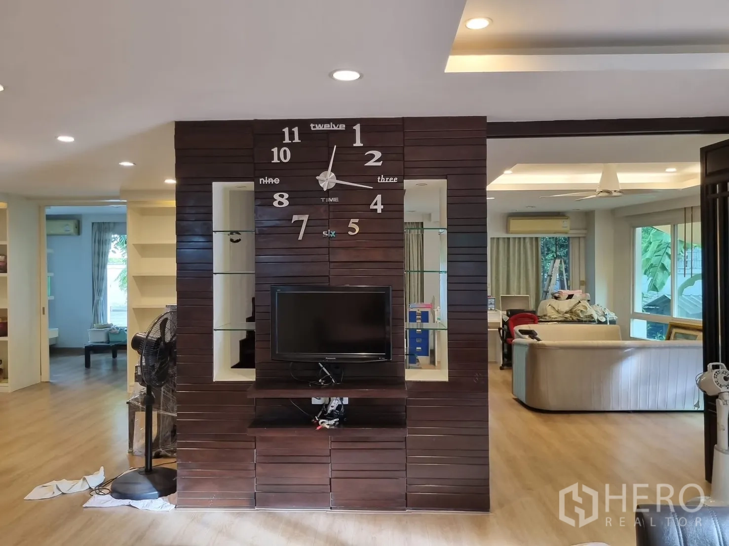 Detached House for rent in Bang Kapi, Bangkok - Feature wall with oversized clock and TV dividing open-plan areas.
