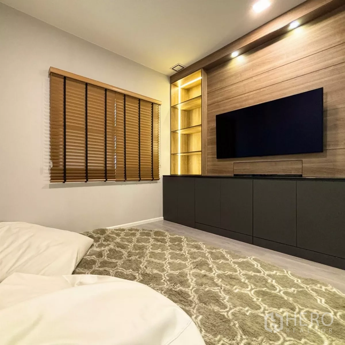 Detached House for rent or sale in Prawet, Bangkok - Cozy media or guest room with wood feature wall, illuminated shelving and mounted TV.
