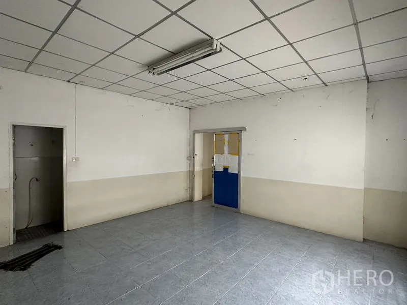 Factory for rent in Phra Nakhon Si Ayutthaya - Simple tiled office room with drop ceiling, fluorescent lighting and internal doorway.