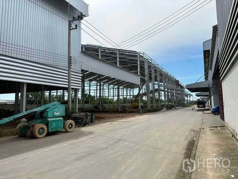 Warehouse for rent in Wang Noi, Phra Nakhon Si Ayutthaya - Steel-framed warehouse complex with wide truck-access road and a boom lift on site.
