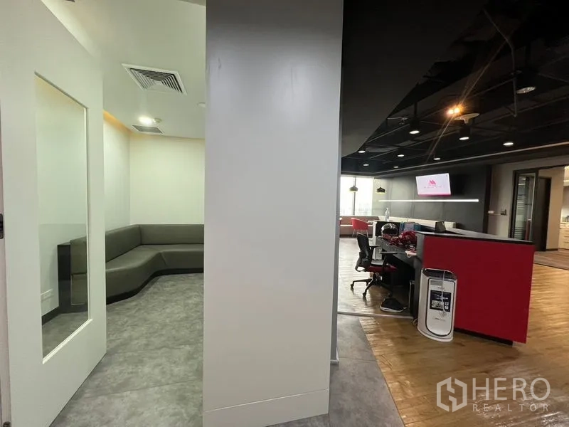 Office Space for rent in Huai Khwang, Bangkok - Reception area with workstations, lounge seating and black ceiling accents.