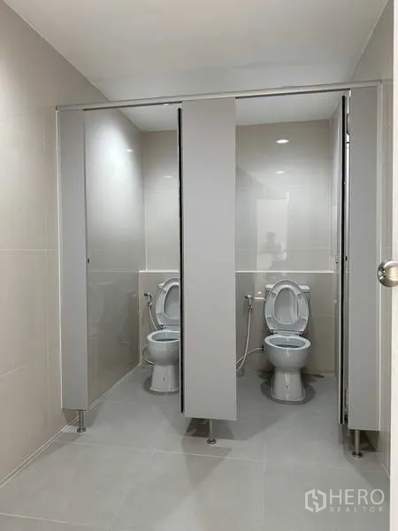Factory for rent in Bang Phli, Samut Prakan - Clean tiled restrooms with private stalls and modern fixtures.
