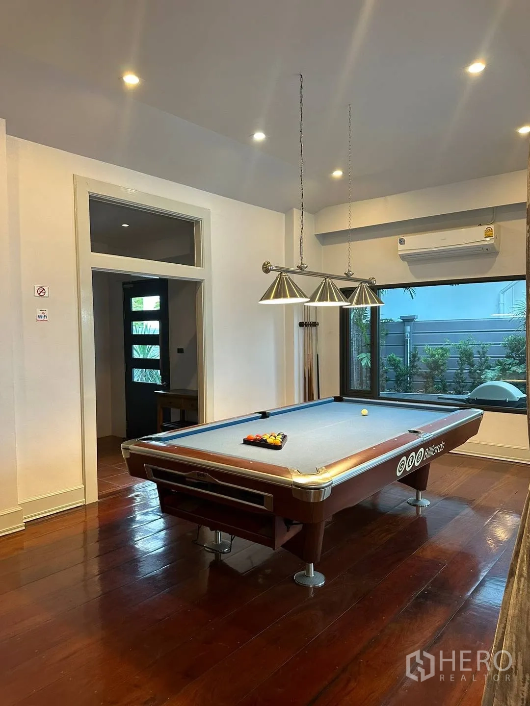 Detached House for rent in Watthana, Bangkok - Games room with billiards table, pendant lights and wood floors.