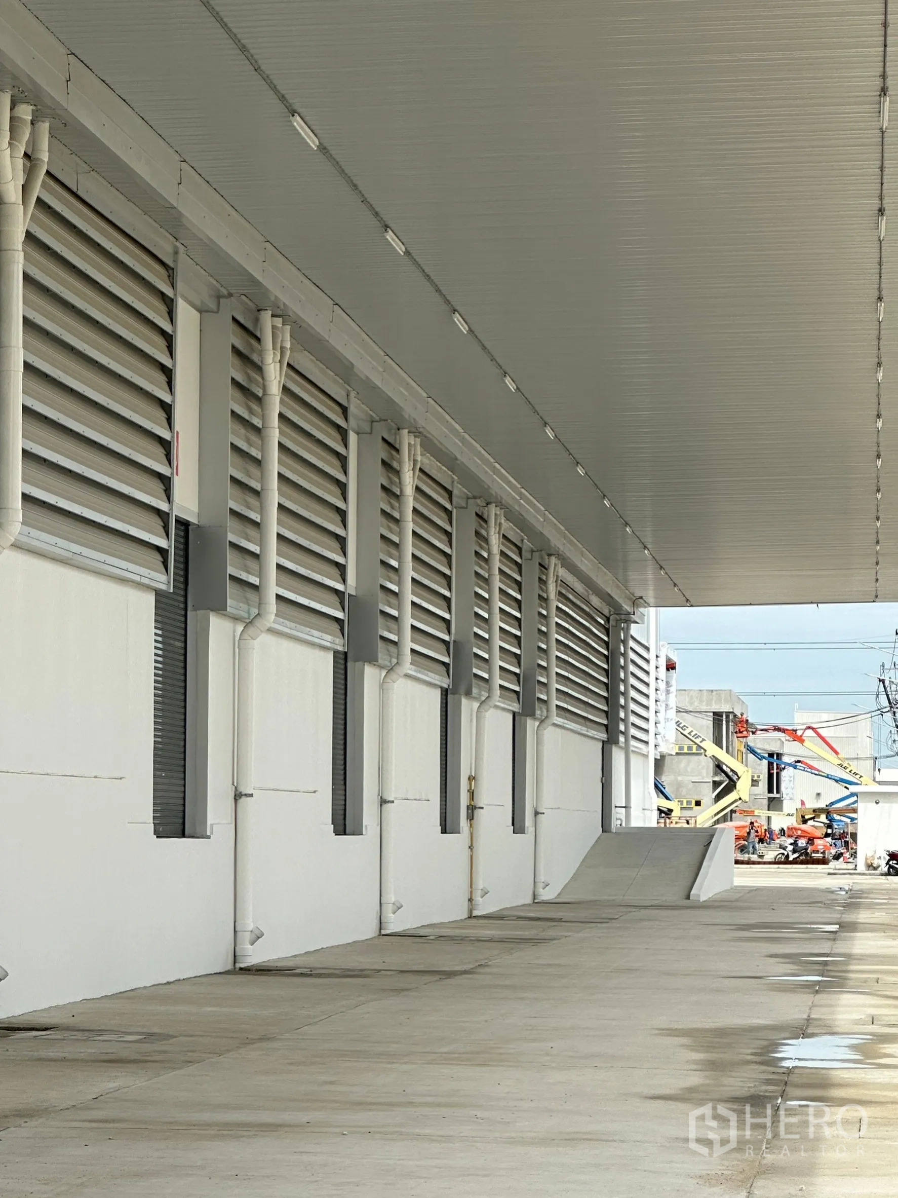 Factory for rent in Khlong Luang, Pathum Thani - Covered loading platform featuring drainage pipes, vents and a truck ramp for easy access.