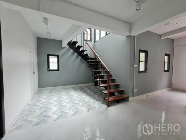 Home Office for rent in Lat Phrao, Bangkok - Open-plan area featuring a modern steel-and-wood staircase and grey accent wall.