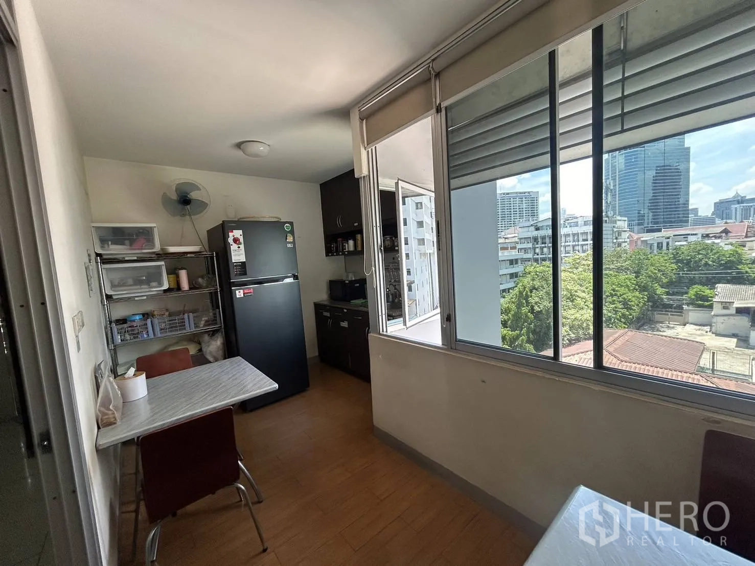 Office Space for rent - Pantry and staff break area with refrigerator, shelving, cabinetry and big sliding windows with city view.