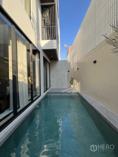 Detached House for sale in Lat Phrao, Bangkok - Narrow private swimming pool along the side courtyard beside the glass façade.