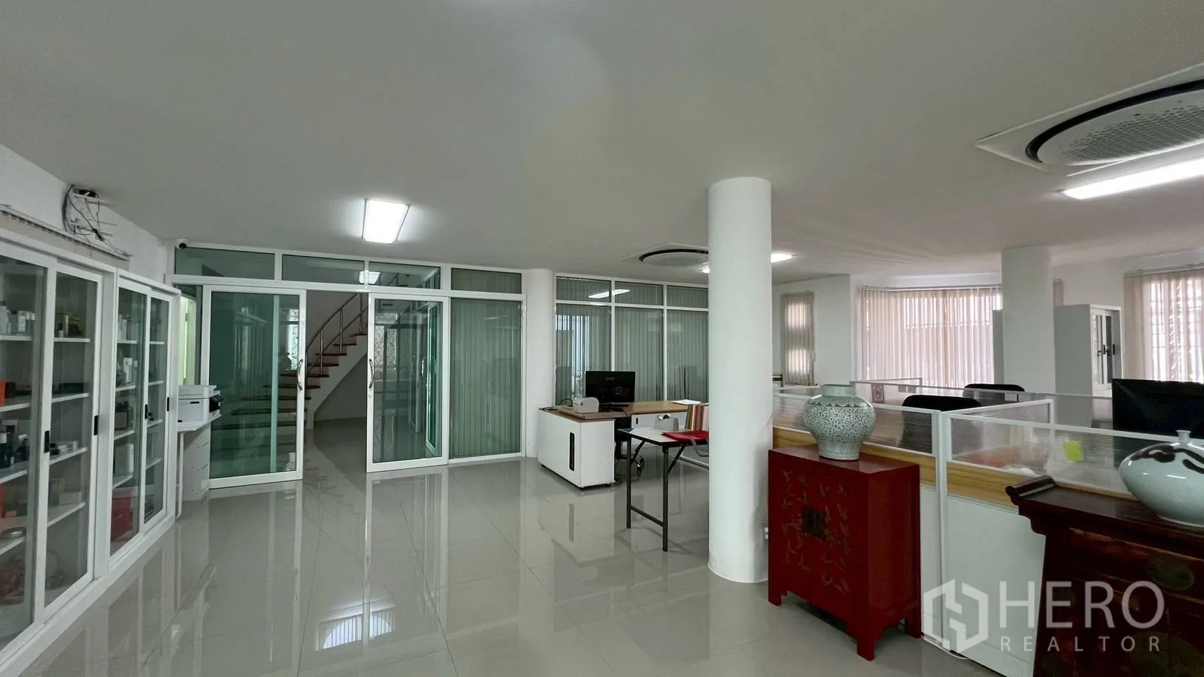 Home Office for rent in Wang Thonglang, Bangkok - Open office showing staircase, glass doors and display cabinets.