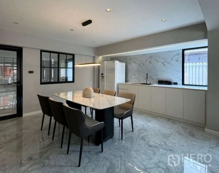 Townhouse for rent or sale in Prawet, Bangkok - Spacious dining area with marble-top table and minimalist pantry.