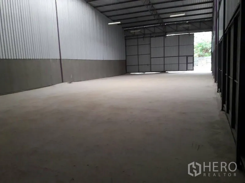 Warehouse for rent in Lam Luk Ka, Pathum Thani - Open-plan warehouse space with wide sliding doors and ample loading area at the entrance.