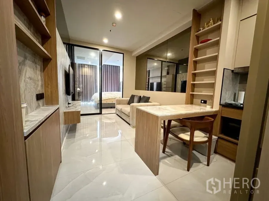 Condominium for rent in Pathum Wan, Bangkok - Bright lounge facing the bedroom through sliding glass, tiled floors and custom built-ins.