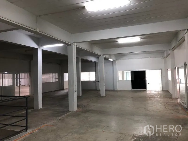 货栈 出租在Khlong Sam Wa, Bangkok - 宽敞仓库楼层，混凝土地坪、白色立柱与明亮灯带。