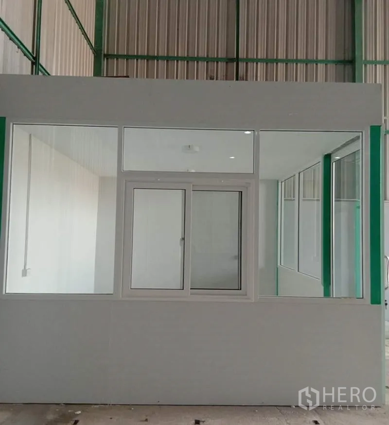 Warehouse for rent in Bang Bua Thong, Nonthaburi - Close-up of internal office cabin with sliding window inside the warehouse.