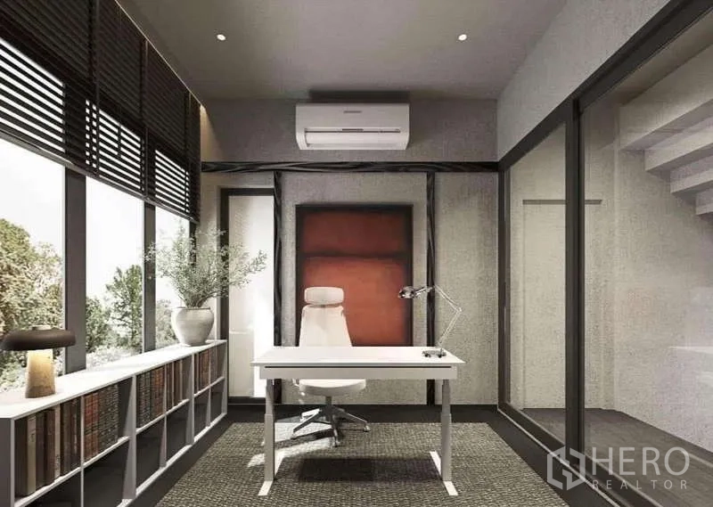 Townhouse for rent in Suan Luang, Bangkok - Bright home office with desk, bookshelves, and wall-to-wall windows.