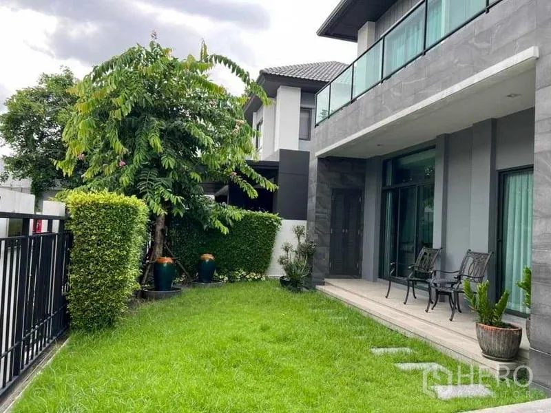 Detached House for sale in Khan Na Yao, Bangkok - Private front garden with trimmed hedges, patio seating and sliding glass doors.