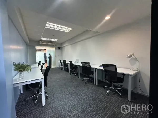Office Space for rent in Watthana, Bangkok - Open-plan workspace with multiple workstations, a frosted-glass entrance and carpet flooring.