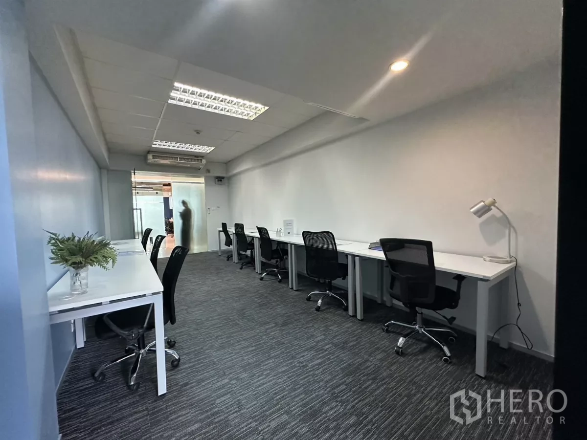 Office Space for rent in Watthana, Bangkok - Open-plan workspace with multiple workstations, a frosted-glass entrance and carpet flooring.