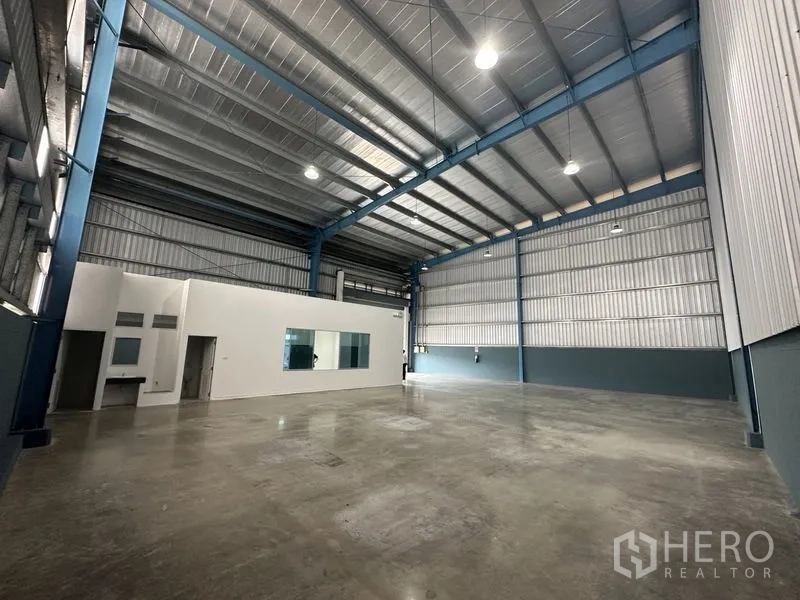 Factory for rent in Bang Phli, Samut Prakan - High-bay industrial hall with blue steel beams, insulated roof panels and smooth concrete flooring.