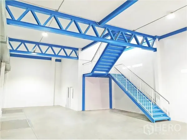 Warehouse for rent in Lat Krabang, Bangkok - Mezzanine-ready interior with blue steel staircase, ideal for office or extra storage within the warehouse.