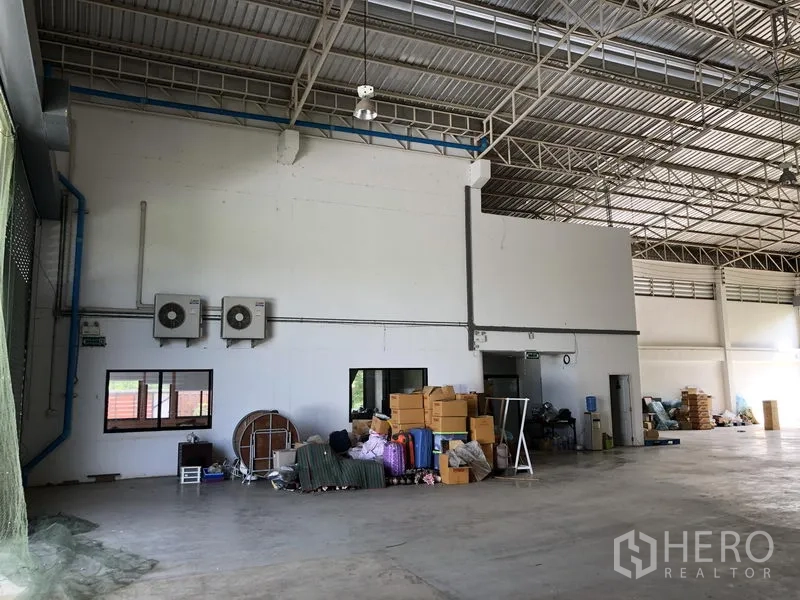 工厂 出租或出售在Lat Lum Kaeo, Pathum Thani - 仓库一角，壁挂空调、储物区与钢结构屋面。
