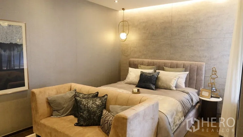 Detached House for sale in Prawet, Bangkok - Cozy master bedroom with upholstered bed, pendant lights and a sofa bench.