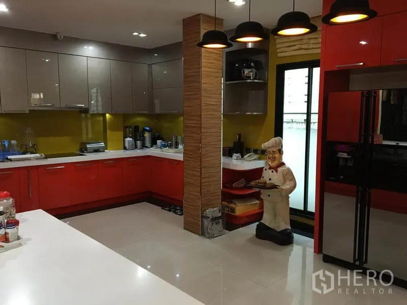 独立式住宅 出租在Khlong Toei, Bangkok - 宽敞厨房，红灰橱柜、操作台与吊灯照明。