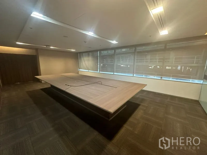 Office Space for rent in Khlong Toei, Bangkok - Secondary meeting room with a long table beside full-height windows and blinds.