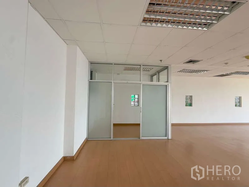 Office Space for rent in Chatuchak, Bangkok - Glass-partitioned room with sliding doors inside an unfurnished office floor.