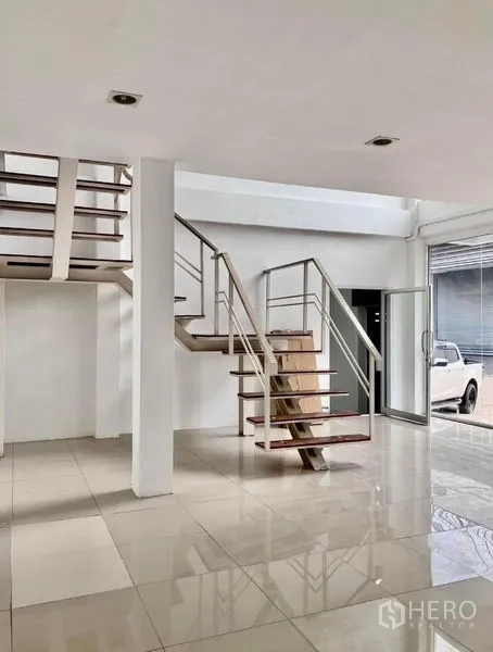 Warehouse for rent in Prawet, Bangkok - Open-tread staircase connecting showroom area to mezzanine offices.