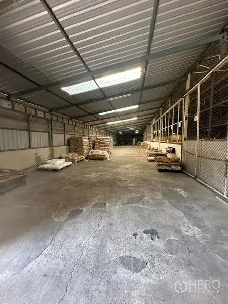 货栈 出租在Yan Nawa, Bangkok - 仓库长走道，采光板天窗、混凝土地面与网格分区。