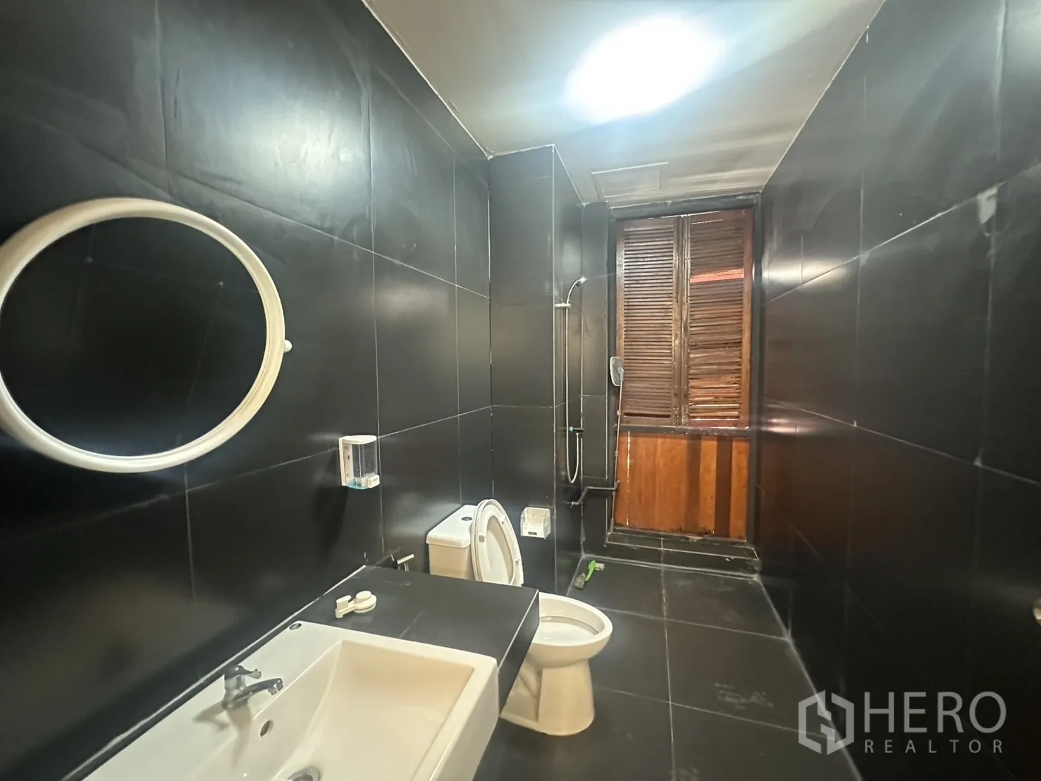 Home Office for rent in Pathum Wan, Bangkok - Second restroom with shower set and modern fixtures in dark tile.