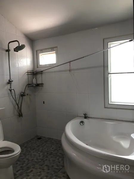 Detached House for sale in Lam Luk Ka, Pathum Thani - Bathroom with corner bathtub, shower and windows.