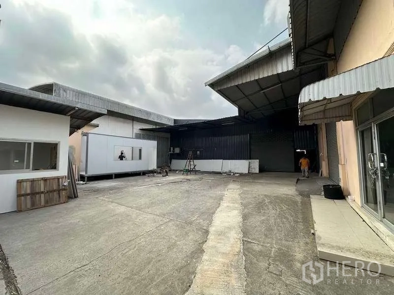 Warehouse for rent in Khlong Luang, Pathum Thani - Spacious warehouse courtyard with covered loading bays and office units.