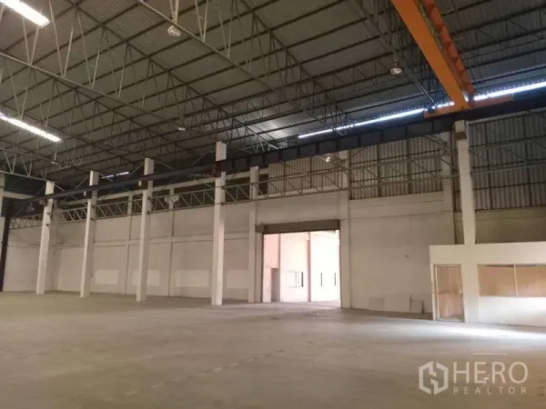 Factory for rent in Mueang Samut Prakan, Samut Prakan - Wide clear-span warehouse floor with tall access door and overhead crane rails along the bay.