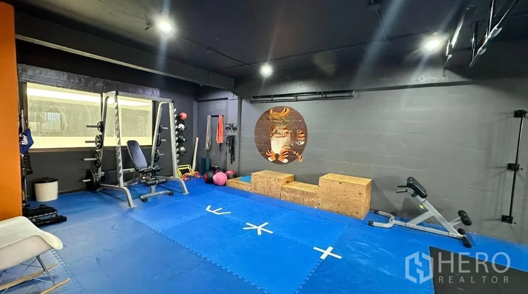 Office Space for rent in Huai Khwang, Bangkok - Open gym-style room with blue mats, squat rack, dumbbells, and plyo boxes.