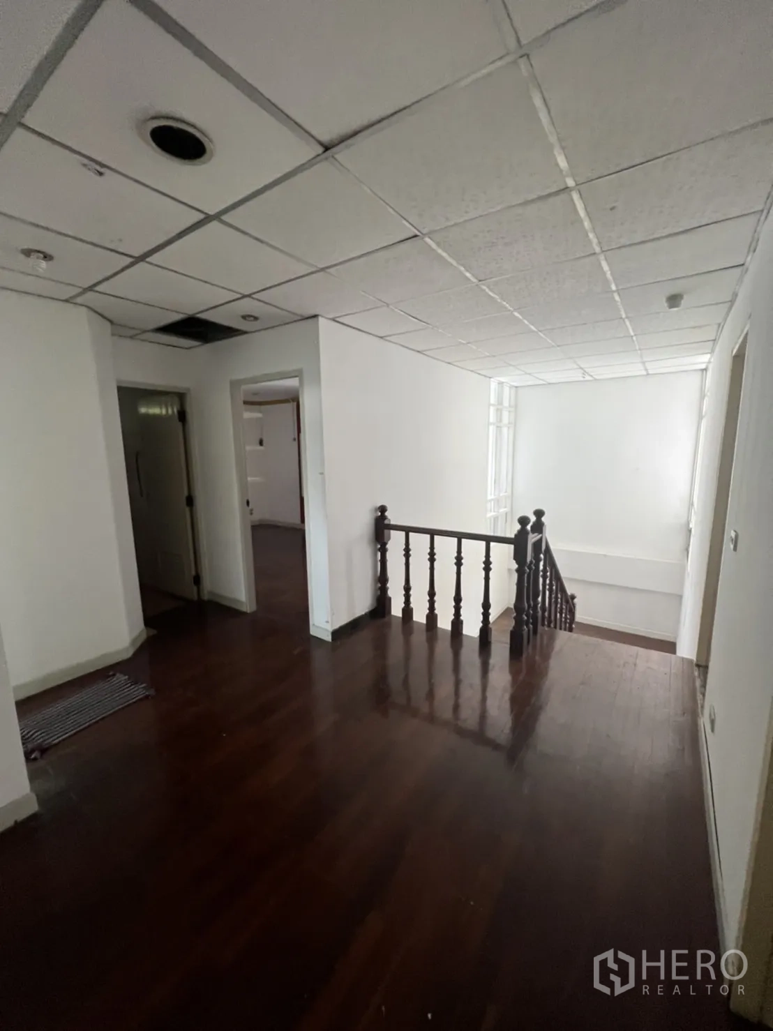 Detached House for rent or sale in Sathon, Bangkok - Upper landing with wood flooring and staircase railing connecting bedrooms.
