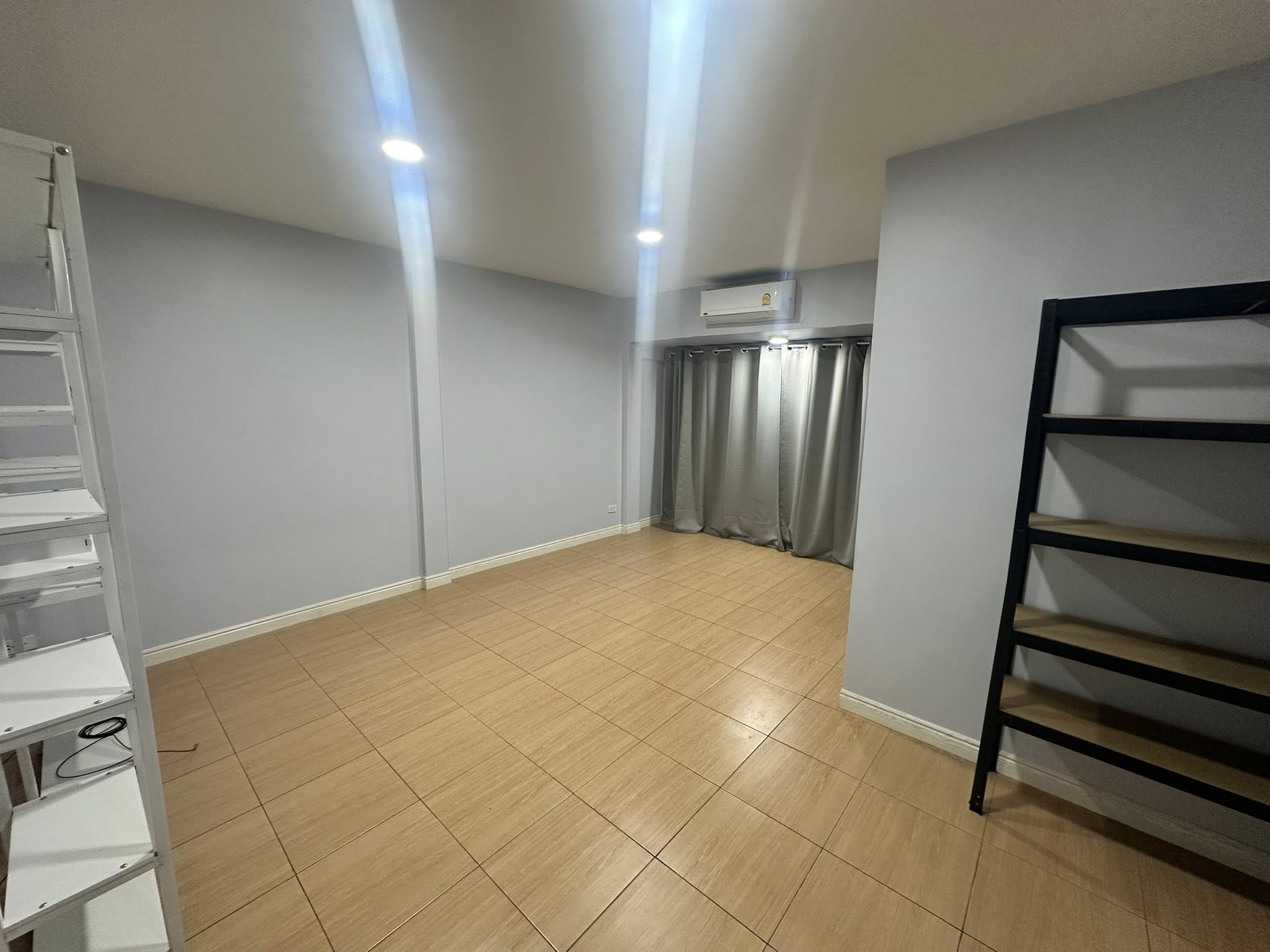 Home Office for rent in Wang Thonglang, Bangkok - Multipurpose room with wood-look tiles, shelves and air conditioner.