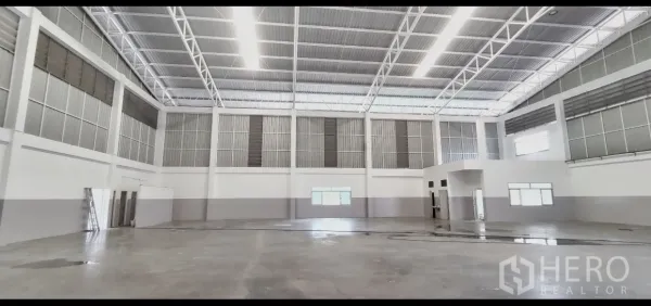 Factory for rent in Mueang Samut Prakan, Samut Prakan - Bright warehouse interior showing clear-span layout and evenly distributed LED lighting.