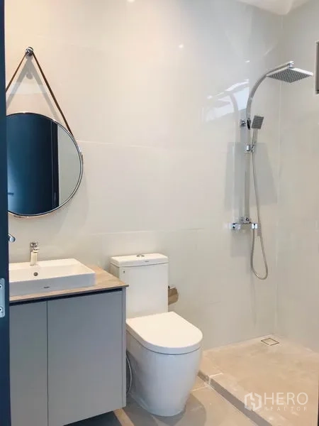 Townhouse for rent or sale in Khlong Toei, Bangkok - Sleek bathroom with walk-in rain shower, vanity and round mirror.