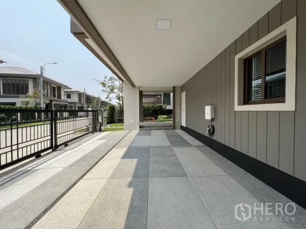 Detached House for rent in Bang Kapi, Bangkok - Spacious shaded parking area with tiled floor facing a quiet street.