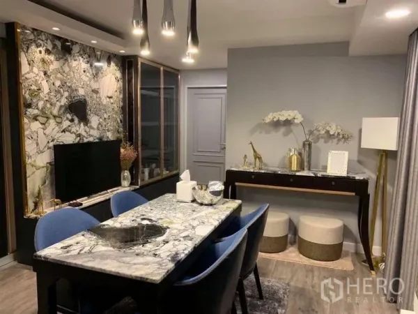 Condominium for sale in Khlong Toei, Bangkok - Dining area with a marble-top table, sleek pendant lights, built-in display cabinets and a decorative console.
