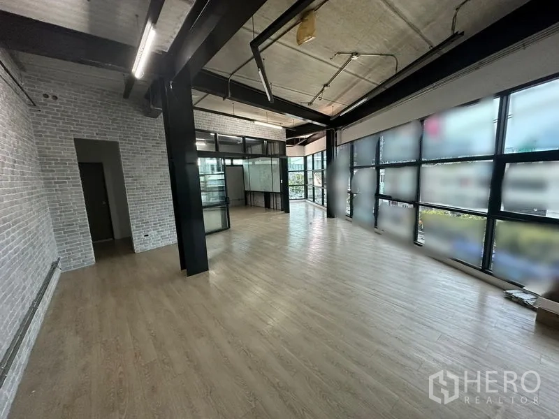 Office Space for rent in Chatuchak, Bangkok - Spacious workspace with black steel columns, brick walls, and linear ceiling lights.